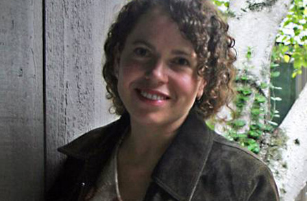 Headshot of poet Rachel Contreni Flynn in front of a fence.